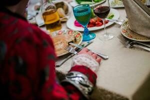 le homme dans ancien costume séance à le de façon festive servi table photo