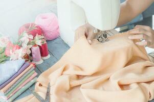 tailleur travail sur une couture machine avec Orange en tissu photo