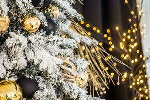 Noël arbre décoré avec fleurs et des oiseaux. original décorations sur branches de Noël arbre, Nouveau année concept. bokeh guirlandes dans Contexte. photo