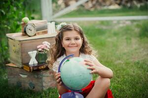 mignonne écolière fille chercheur explore le globe dans le parc. aventure, rêver à propos Voyage la vie concept. retour à école concept photo