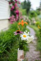 bouquet de été fleurs dans une vase permanent sur une sentier près le maison photo