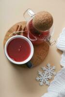 plat allonger tasse et verre théière avec canneberge thé et plaid avec flocons de neige. confortable hiver chaud boisson Haut vue photo