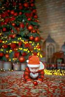 peu surpris enfant dans Père Noël costume dans de fête pièce sur Noël veille. fille sur Contexte de Noël arbre. photo