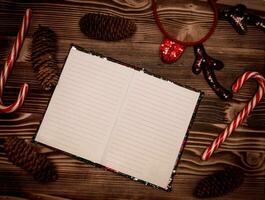 Vide carnet pour Père Noël souhait enregistrements sur en bois Contexte. révélé journal intime pages avec une plan pour Noël et le Nouveau 2021. Noël concept plat allonger photo