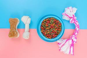 nourriture pour animaux de compagnie dans un bol bleu avec accessoires sur fond de couleur photo