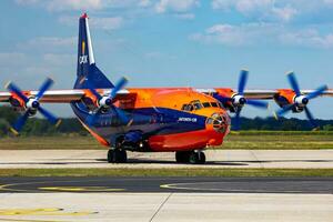 cavok air antonov an-12 cargaison avion à aéroport tablier avec marshaller. air cargaison et expédition. aviation et avion. transport industrie. global international transport. mouche et en volant. photo