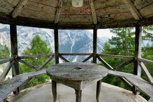 une belvédère avec une table et bancs surplombant le montagnes photo