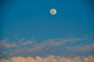 le lune est vu dans le bleu ciel avec des nuages photo