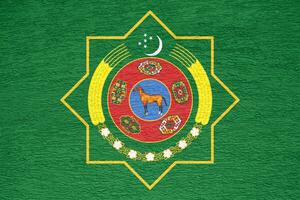 drapeau et manteau de bras de turkménistan sur une texturé Contexte. concept collage. photo