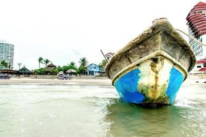 la plage de sable et la mer avec bateau qui stationne sur le front de mer. photo