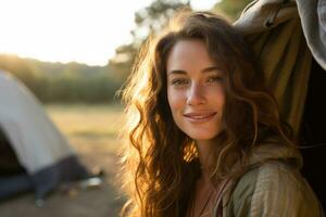 portrait de fille à la recherche à caméra tandis que près camping tente à le coucher du soleil ai généré photo