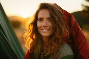 portrait de fille à la recherche à caméra tandis que près camping tente à le coucher du soleil ai généré photo