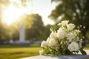 blanc fleurs dans de face de une pierre tombale à une cimetière avec coucher de soleil.funérailles concept ai généré photo