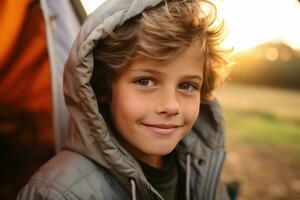 portrait de une mignonne garçon à la recherche à caméra tandis que près le sien tente dans la nature ai généré photo