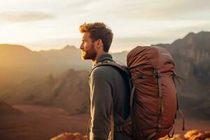 Beau Jeune homme avec sac à dos randonnée dans le montagnes à le coucher du soleil ai généré photo