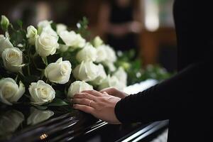 fermer de une femme main placement une bouquet de blanc des roses dans une cercueil.funérailles concept ai généré photo