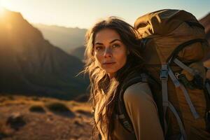 magnifique femme promeneur avec sac à dos randonnée dans le montagnes à le coucher du soleil ai généré photo