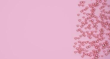 minimaliste flatlay composition avec rose décoratif des balles sur une rose Contexte. vacances concept. copie espace. Haut voir. photo