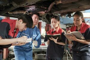 spécialiste conférence, Masculin superviseur ingénieur décris de l'essence automobile fixation avec mécanicien ouvrier Personnel équipes pour réparation travail à voiture un service garage et entretien emplois dans voiture industrie. photo