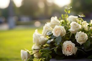 blanc fleurs dans de face de une pierre tombale à une cimetière avec coucher de soleil.funérailles concept ai généré photo