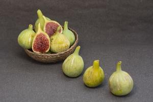 figues fraîches tranchées dans un panier sur fond gris et sur le dessus photo