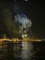 coloré feux d'artifice dans le nuit ciel sur le front de mer de alicante Espagne photo