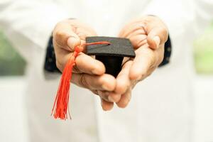 étude de médecin asiatique apprendre avec un chapeau d'écart de graduation dans la salle d'hôpital, concept de médecine d'éducation de génie brillant intelligent. photo