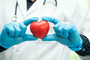 médecin tenant un coeur rouge dans la salle d'hôpital, concept médical solide et sain. photo