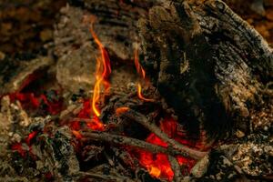 flamme de texture provenant de la combustion de bûches la nuit photo