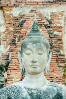 une Bouddha statue est dans de face de une brique mur photo