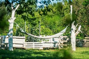 une hamac bloque dans le jardin. du repos près le maison ou chalet sur une ensoleillé journée. photo