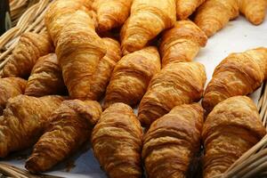 beaucoup des croissants sur sur une noir table dans une boulangerie magasin. photo