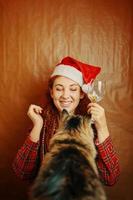 femme rousse en bonnet de père noël et chat moelleux photo