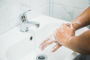 gros plan des mains masculines se lavant les mains avec du savon. photo