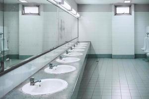 toilettes publiques et salle de bain intérieure avec lavabo et salle de toilette. photo