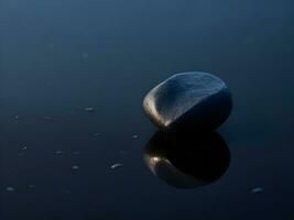 une peu galets sur le surface de doucement ondulation bleu l'eau ai produire photo