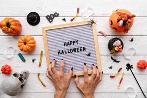 joyeux halloween mots sur tableau gris avec des bonbons et une femme effrayante photo