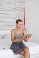jeune femme faisant du shopping en ligne assise à la maison sur le lit photo