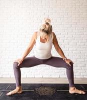 femme blonde pratiquant le yoga à la maison photo