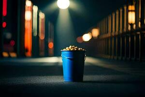 une bleu seau rempli avec pop corn sur une foncé rue. généré par ai photo