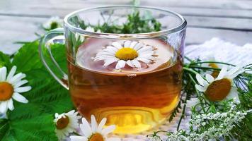 fleurs et une tasse de thé sur un fond en bois photo