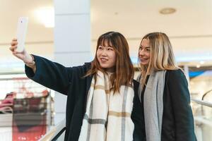 Multi-éthnique magnifique couple de copines prendre une selfie avec une téléphone intelligent photo