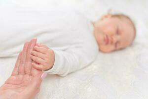 Jeune femme en portant petit main de sa en train de dormir bébé fille dans chambre photo