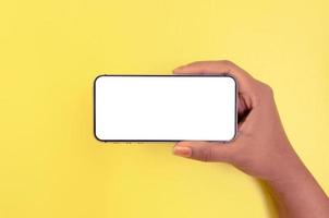 une main tenant un smartphone avec un fond d'écran blanc. photo