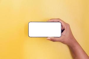 une main tenant un smartphone avec un fond d'écran blanc. photo