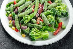 congelé des légumes mélanger brocoli, maïs, carottes, vert petits pois, vert haricots, cloche poivrons, des haricots Frais délicieux en bonne santé en mangeant cuisine apéritif repas nourriture casse-croûte sur le table photo