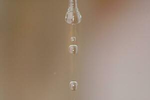 l chute l'eau laissez tomber sur beige Contexte dans fermer photo