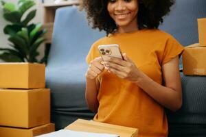 Jeune femme en portant une téléphone intelligent, tablette montrant Paiement Succès avec Jaune parcelle boîte comme en ligne achats concept photo