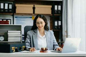 Justice et loi concept. asiatique femelle juge dans une salle d'audience sur en bois table et conseiller ou Masculin avocat travail dans moderne bureau. photo