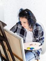 femme créative avec la peinture de cheveux teints en bleu dans son studio photo